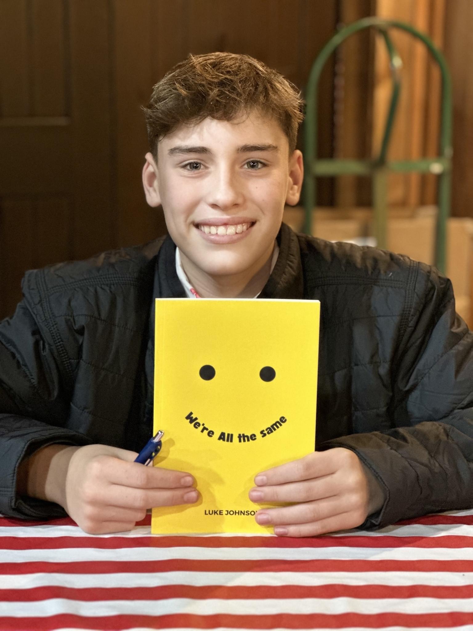 Luke Johnson holding his book We're All The Same